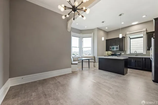 a large kitchen with a large counter top appliances cabinets and furniture