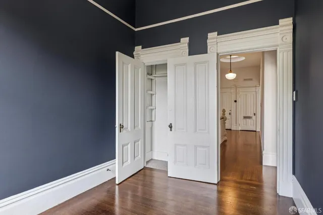 a view of empty room with wooden floor