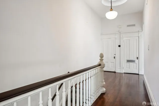 a view of a hallway with wooden floor and staircase