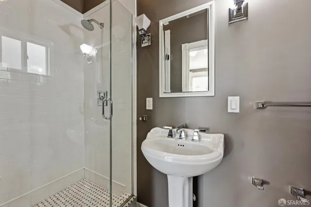 a bathroom with a sink a mirror and shower