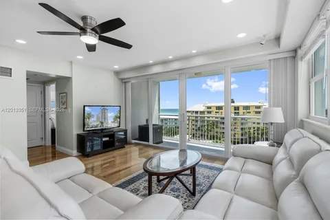 a living room with furniture a ceiling fan and a flat screen tv