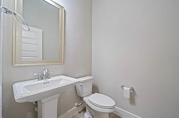 a bathroom with a sink toilet and a mirror