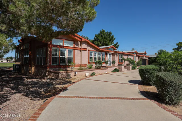 a view of a house with a barbeque and large trees