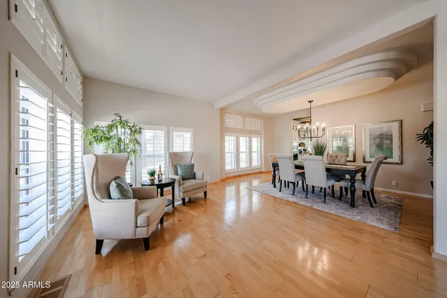 a dining room with furniture a chandelier and wooden floor