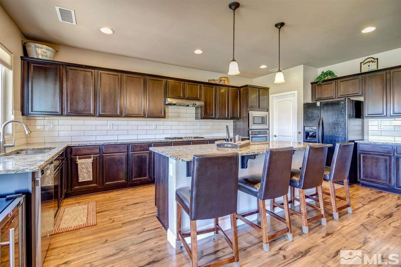 1990 Back Nine Trail Reno, NV 89523 - Photo 4 of 25 a kitchen with stainless steel appliances granite countertop wooden cabinets a stove a sink and a wooden floor