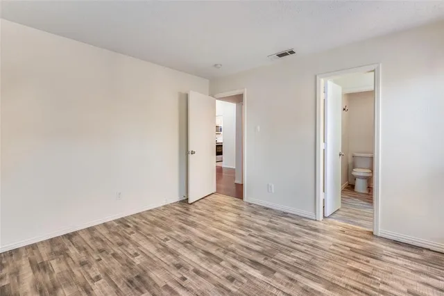 a view of an empty room with wooden floor