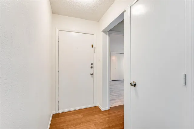 a view of empty room with wooden floor and fireplace