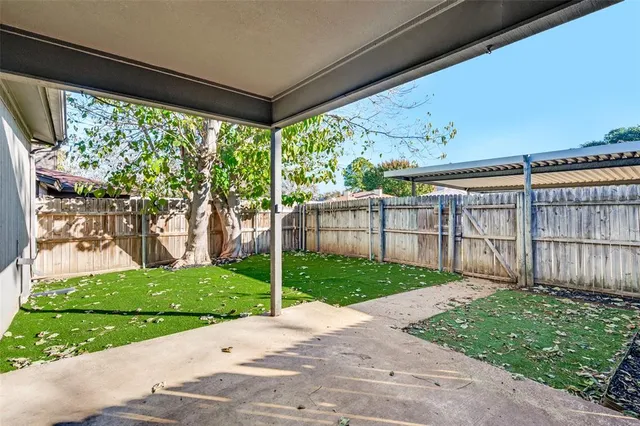 a backyard of a house with plants and wooden fence
