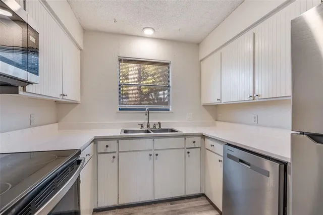 a kitchen with stainless steel appliances a sink stove and cabinets