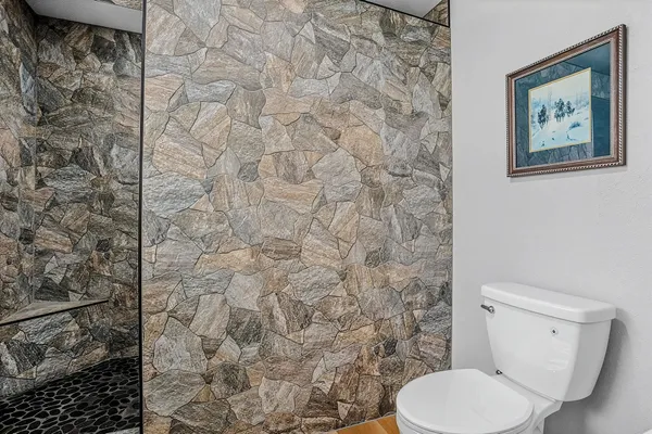 a white toilet sitting next to a white wall