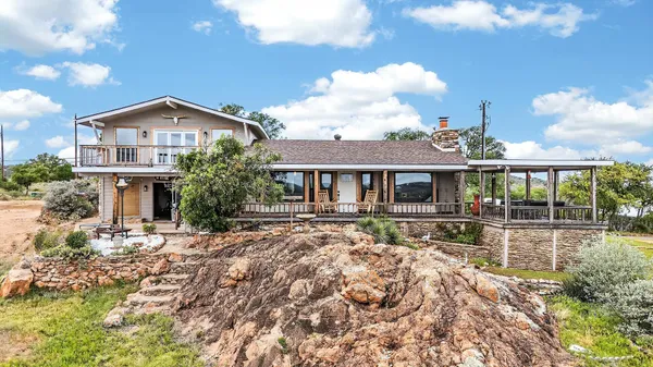 a front view of house with yard outdoor seating and barbeque in forest