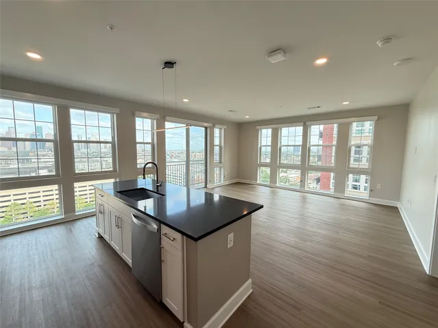 a kitchen with stainless steel appliances granite countertop a sink a stove and wooden floor