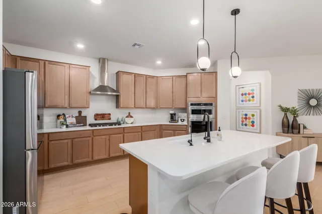 a kitchen with a sink a center island a refrigerator and cabinets