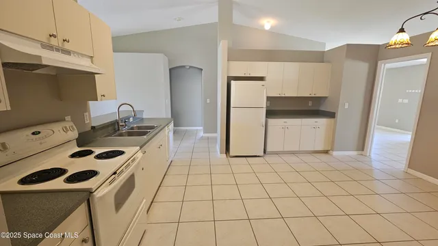 a kitchen with a sink a stove and a refrigerator