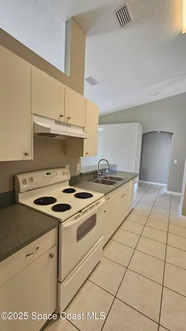 a white stove top oven sitting inside of a kitchen