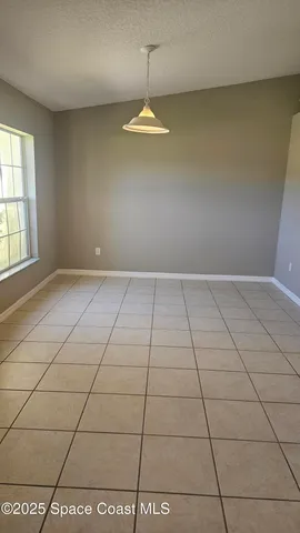 a view of a livingroom with an empty space and a window