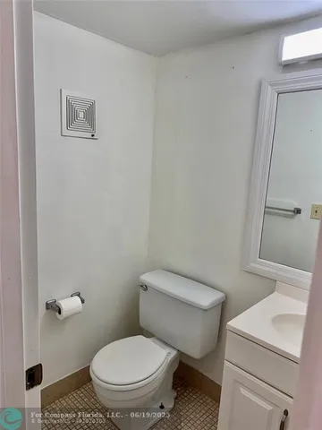 a white toilet sitting next to a white sink and vanity