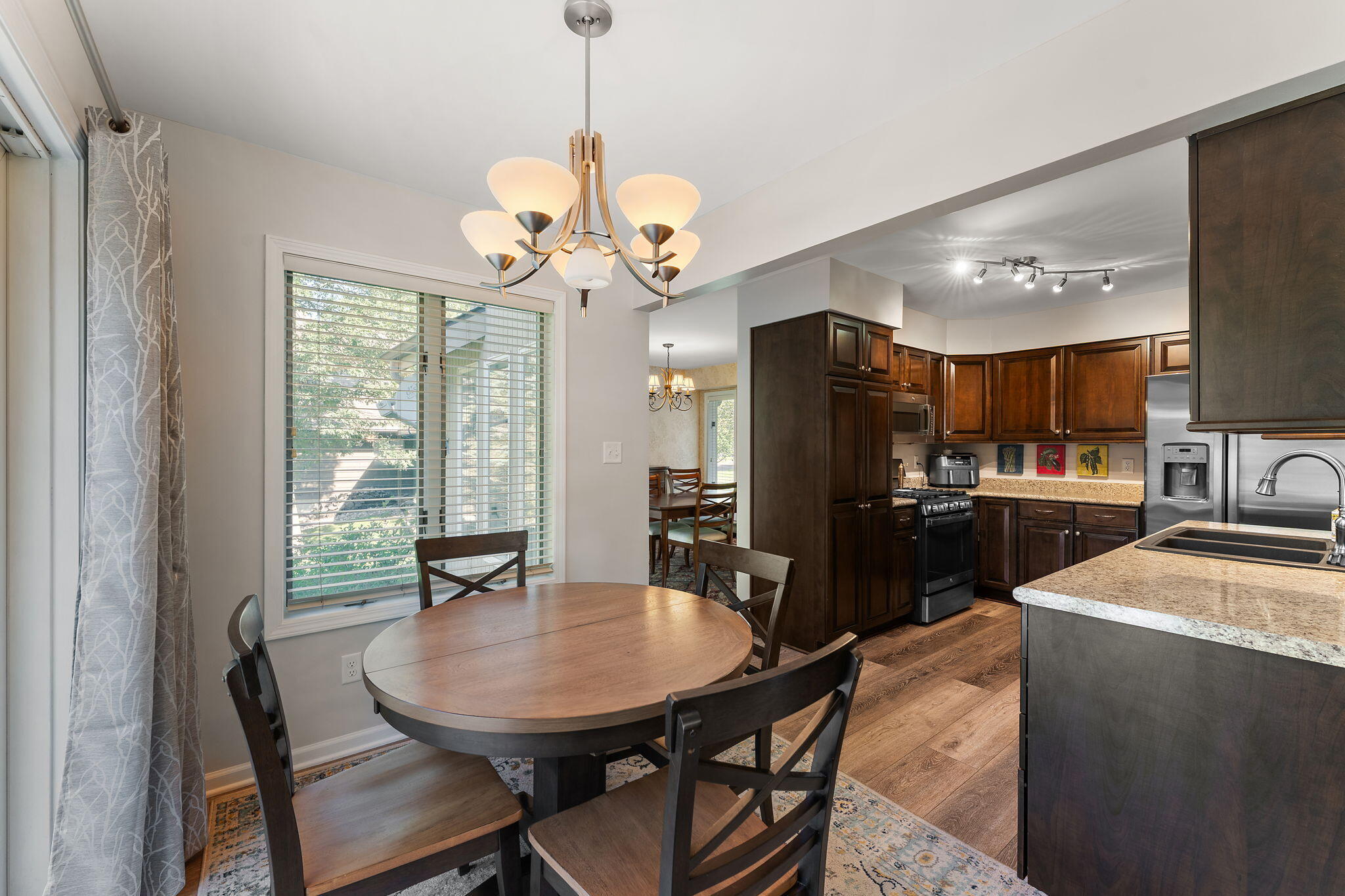 8748 Durbin Lane Crown Point, IN 46307 - Photo 18 of 47 a view of a dining room with furniture a chandelier and wooden floor