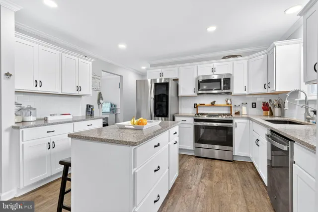 a kitchen with granite countertop white cabinets and white appliances
