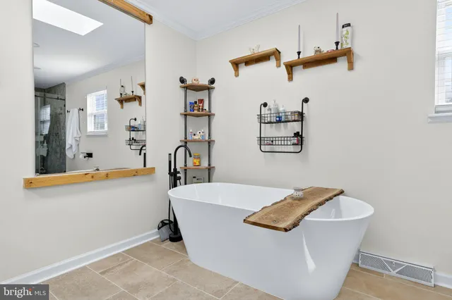 a bathroom with a tub sink and mirror