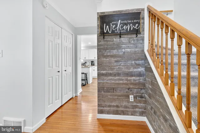 a view of a hallway with wooden floor and staircase