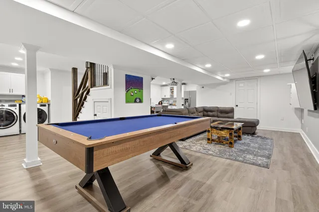 a living room with furniture flat screen tv and pool table