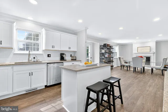 a kitchen with white cabinets and chairs