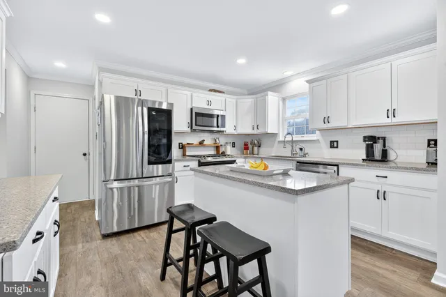 a kitchen with refrigerator cabinets and wooden floor