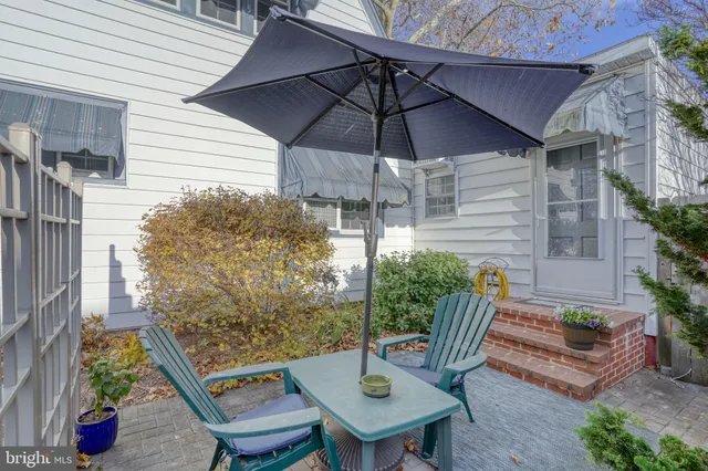a view of a patio with table and chairs under an umbrella