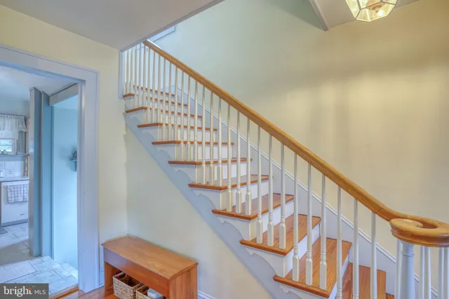 a view of staircase with wooden floor and white walls