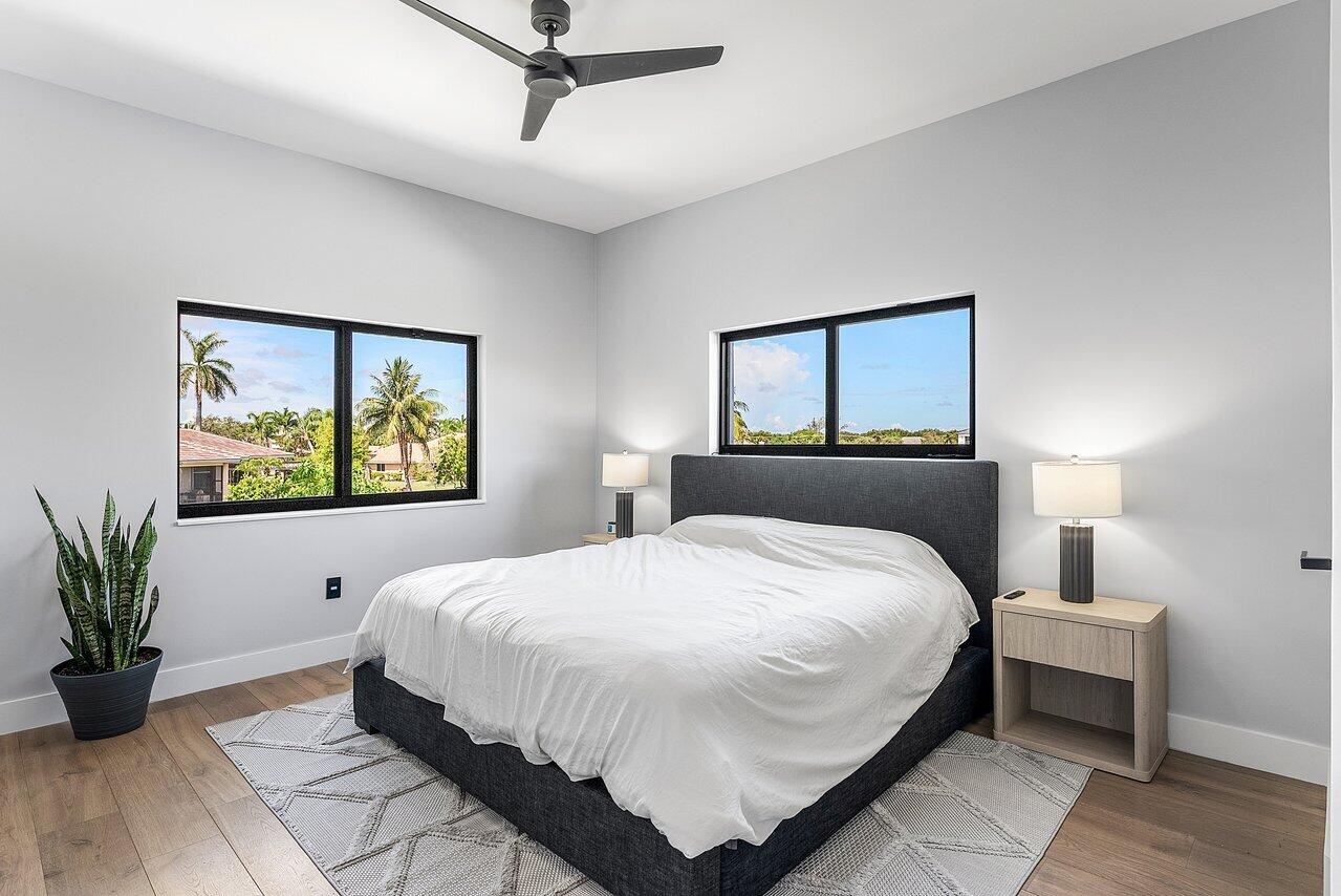 8387 Sawpine Road Delray Beach, FL 33446 - Photo 28 of 57 a bedroom with a large bed and a potted plant