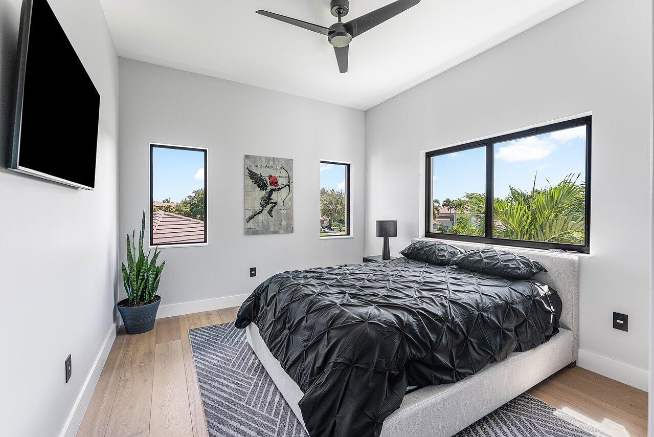 8387 Sawpine Road Delray Beach, FL 33446 - Photo 29 of 57 a bed sitting in a bedroom next to a window