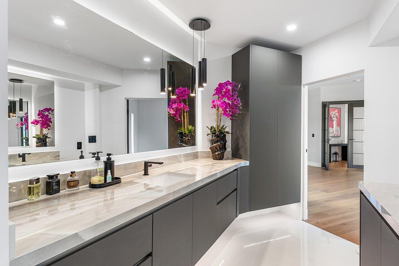 8387 Sawpine Road Delray Beach, FL 33446 - Photo 33 of 57 a bathroom with a granite countertop sink a mirror and a shower