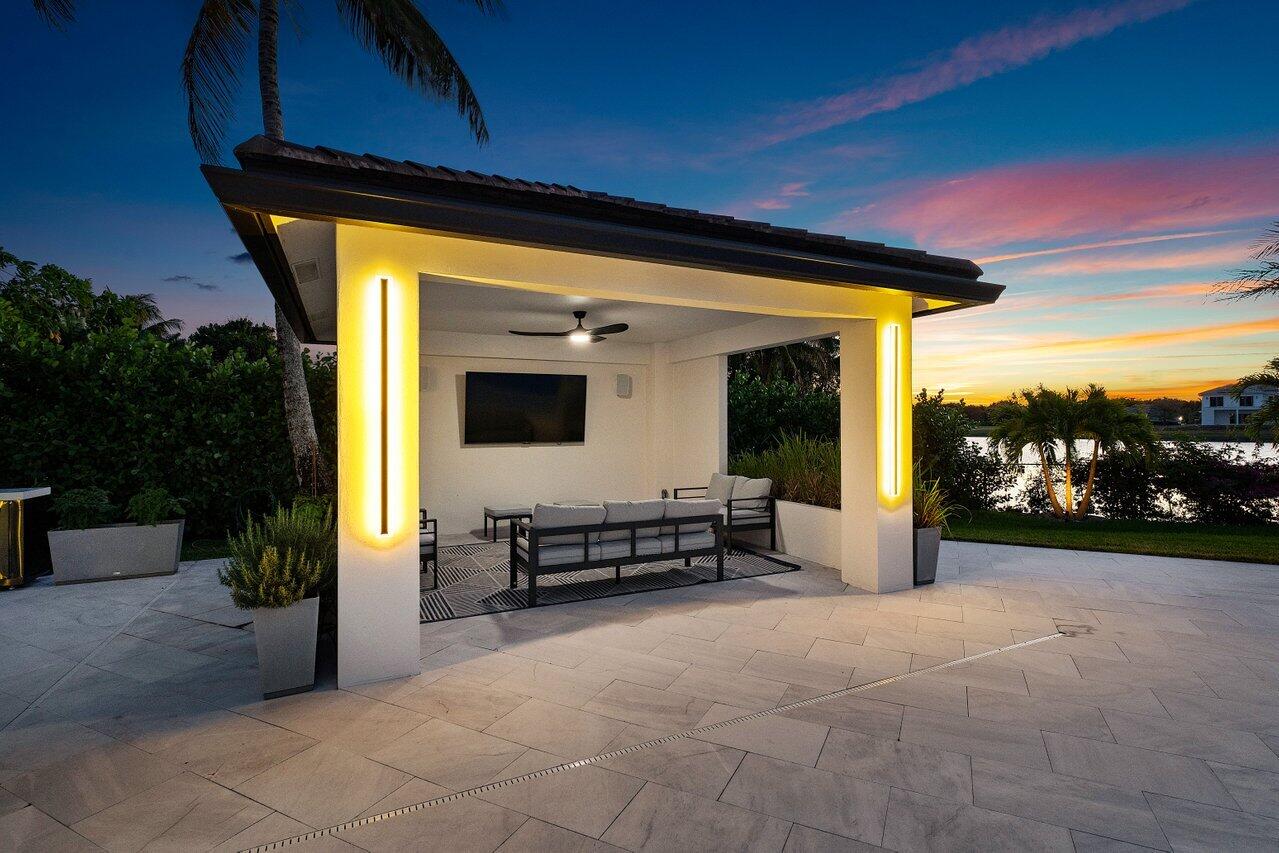 8387 Sawpine Road Delray Beach, FL 33446 - Photo 47 of 57 a view of a porch with a table and chairs under an umbrella