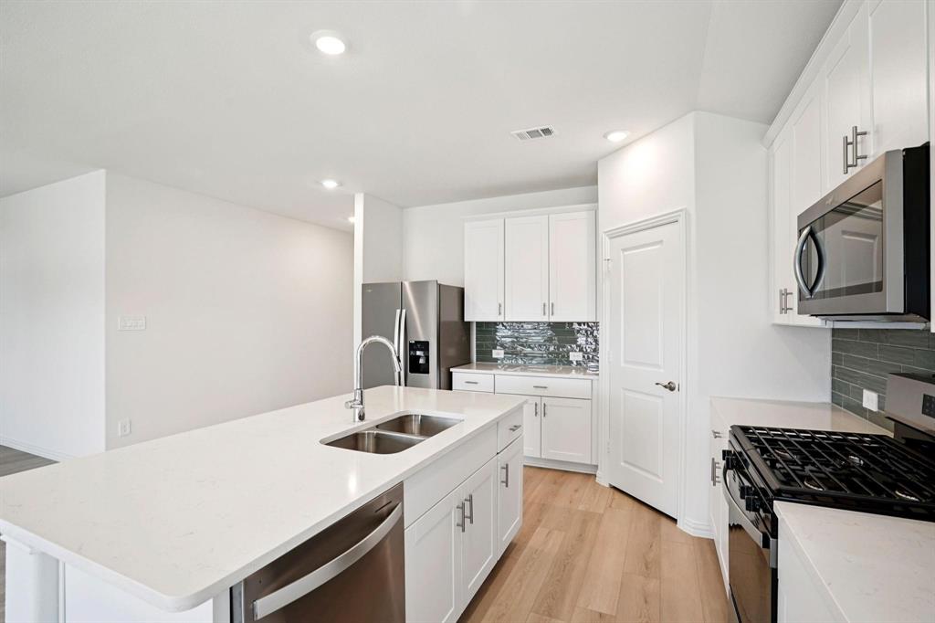 827 Sunflower Road Lavon, TX 75166 - Photo 2 of 23 a kitchen with a sink a stove and refrigerator