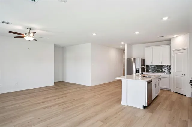 a view of kitchen with stainless steel appliances granite countertop cabinets and wooden floor