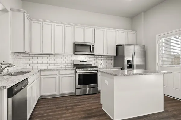 a kitchen with stainless steel appliances granite countertop a stove a sink dishwasher and a refrigerator