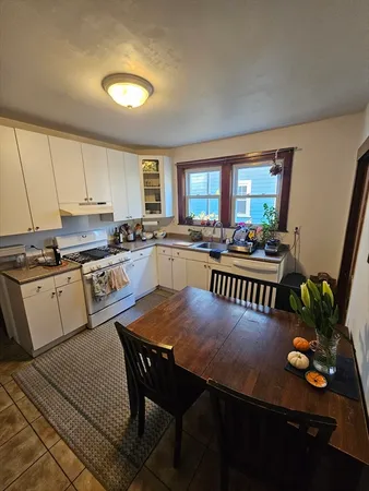 a kitchen with stainless steel appliances granite countertop a stove a sink dishwasher a dining table and chair with wooden floor