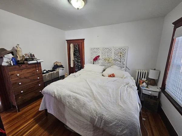 a bedroom with a bed and wooden floor