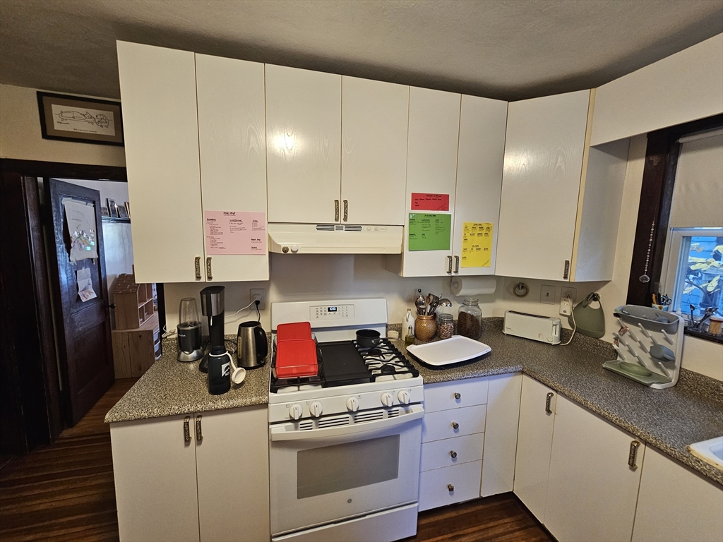 13 Roberts Road Cambridge, MA 02138 - Photo 9 of 23 a kitchen with a sink dishwasher stove and white cabinets