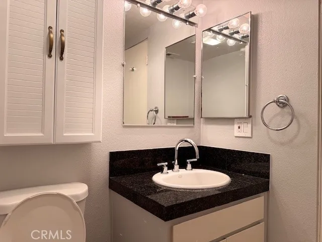 a bathroom with a granite countertop sink and a mirror