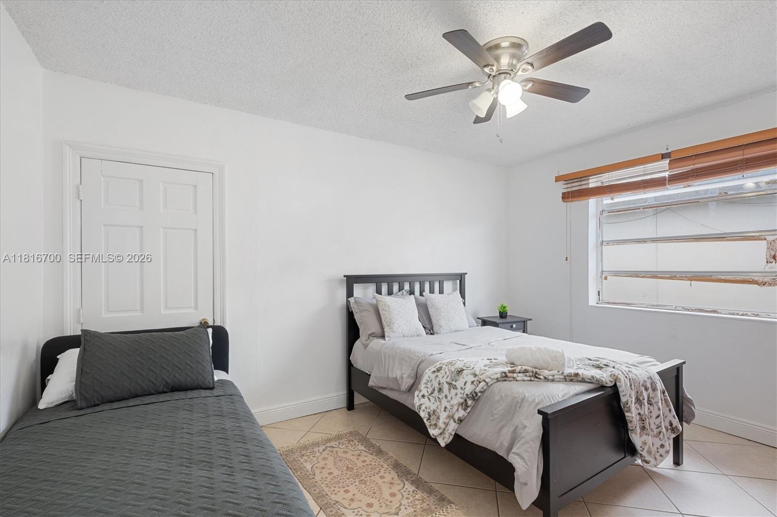5726 Southwest 20th Street Miami, FL 33155 - Photo 14 of 27 a bedroom with a large bed and a ceiling fan