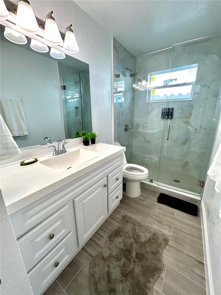 5726 Southwest 20th Street Miami, FL 33155 - Photo 5 of 12 a bathroom with a double vanity sink mirror and toilet