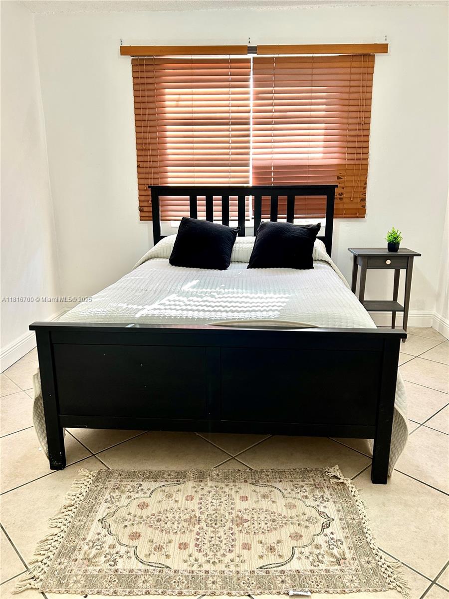 5726 Southwest 20th Street Miami, FL 33155 - Photo 6 of 12 a bedroom with a bed and a table