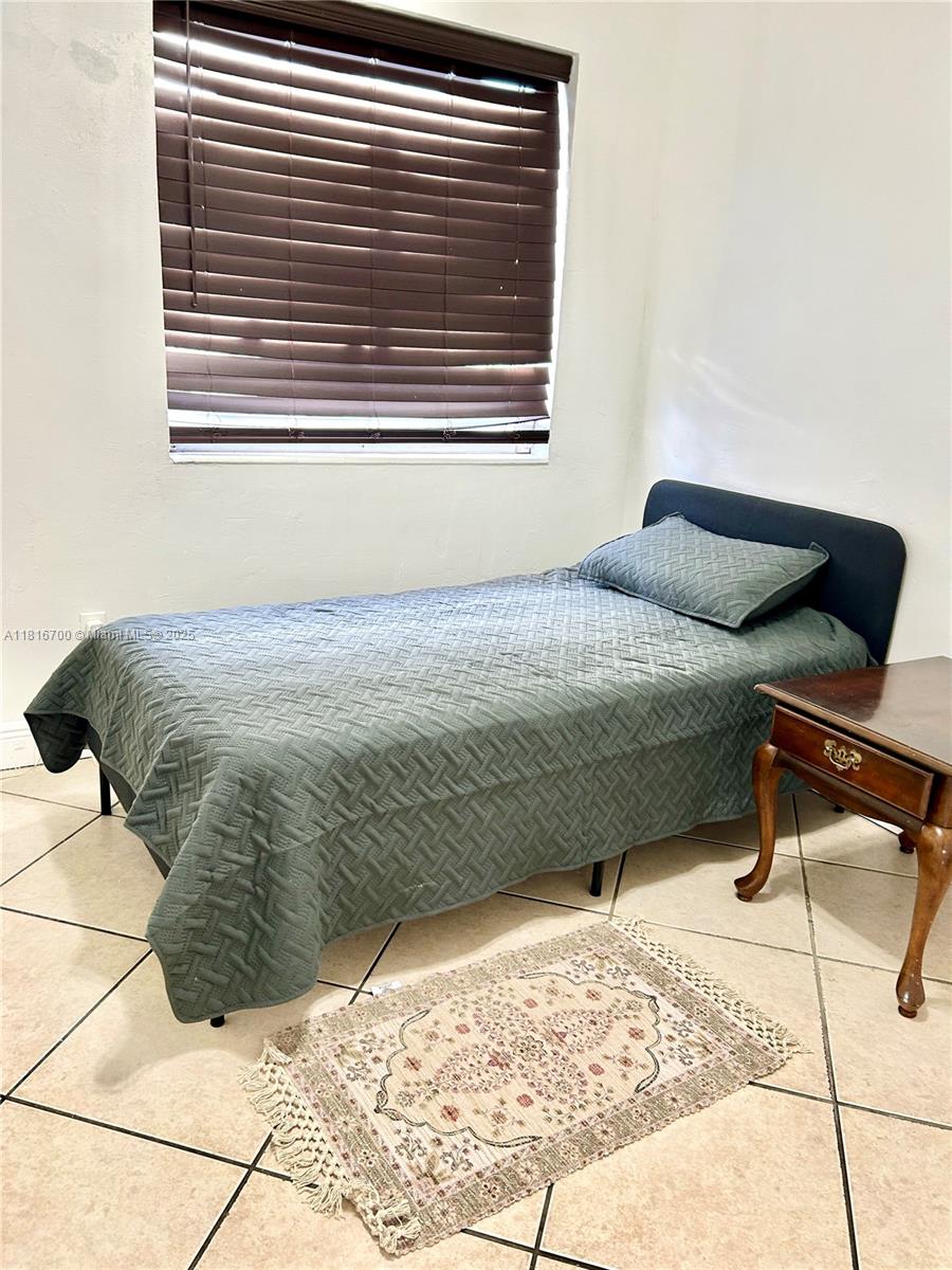 5726 Southwest 20th Street Miami, FL 33155 - Photo 7 of 12 a bedroom with a bed and a window