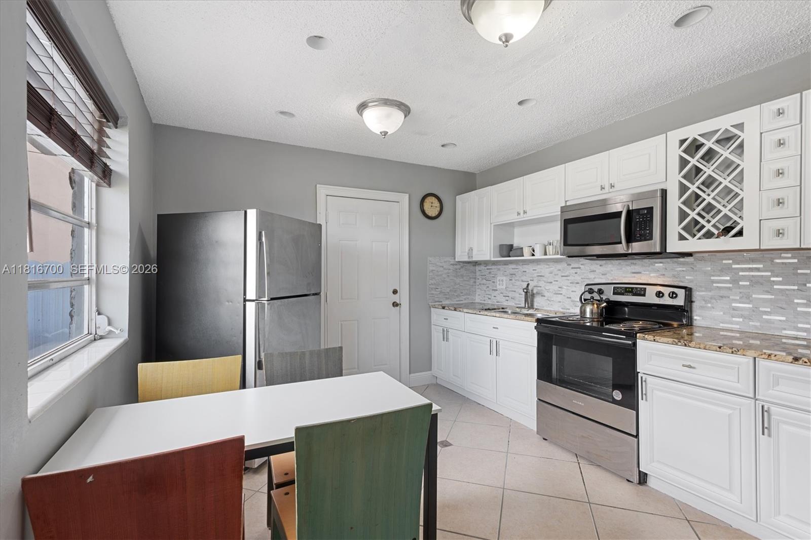 5726 Southwest 20th Street Miami, FL 33155 - Photo 8 of 27 a kitchen with stainless steel appliances granite countertop a refrigerator stove microwave and sink