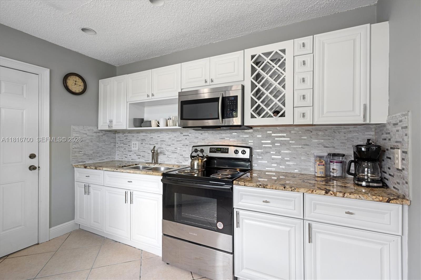5726 Southwest 20th Street Miami, FL 33155 - Photo 9 of 27 a kitchen with white cabinets stainless steel appliances and sink