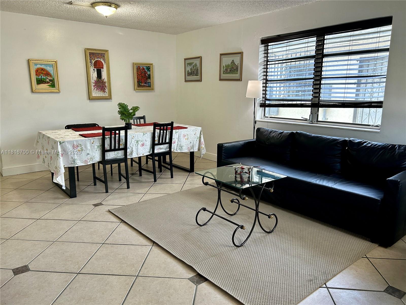 5726 Southwest 20th Street Miami, FL 33155 - Photo 10 of 12 a living room with furniture a desk and chair with windows