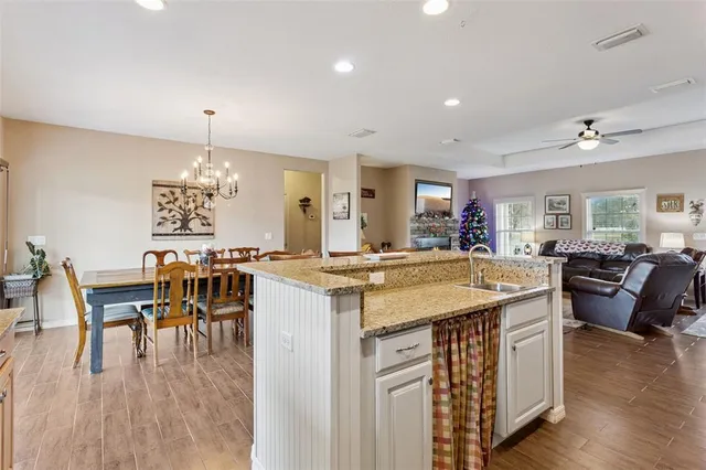 a open kitchen with stainless steel appliances granite countertop a stove and a dining table