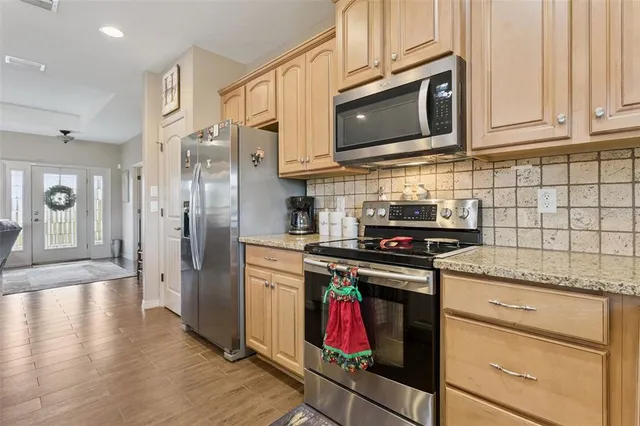 a kitchen with stainless steel appliances granite countertop a stove microwave and cabinets
